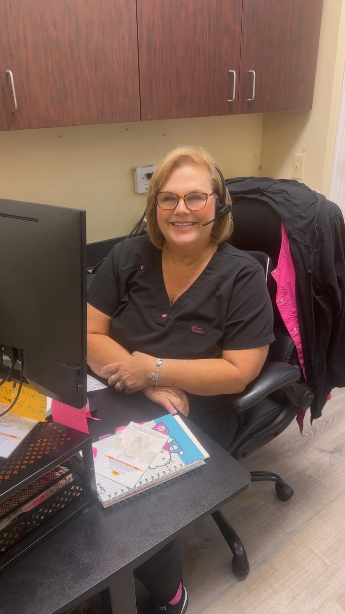 Staff member at Florida Bladder Institute seated at a clinical desk with computer and patient materials